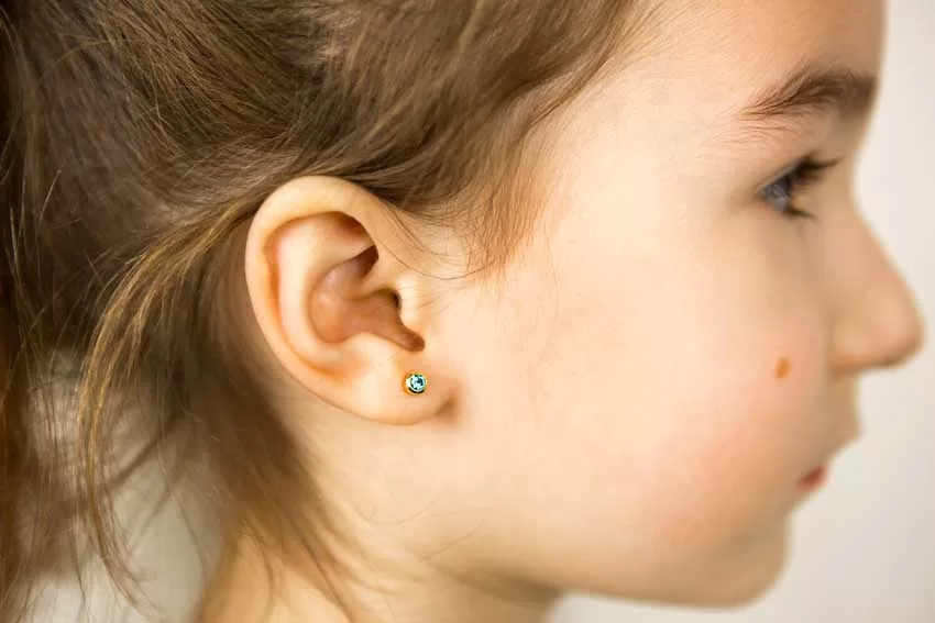 Child wearing stud earrings