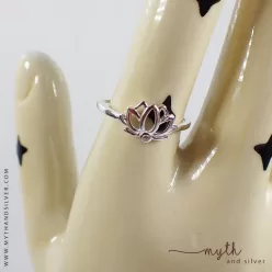 Silver lotus ring shown on ceramic hand